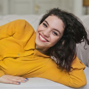 Smiling woman laying on a sofa