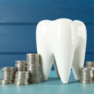 A large ceramic tooth surrounded by silver coins