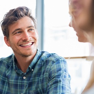 Man in blue shirt smiling at friend