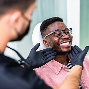 Dentist looking at patient's smile in treatment room