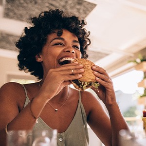 Woman smiling while enjoying meal in restaurant