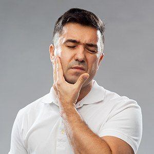 Man in pain holding cheek