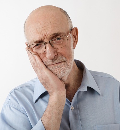 Older man in pain holding jaw