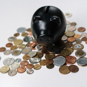 Black piggy bank and loose coins