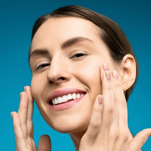 Smiling woman with her hands on her face