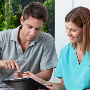 A man paying the cost of dental crowns