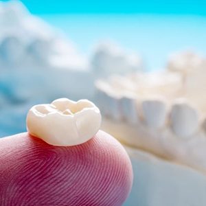 close up of a dental crown on a person’s finger 