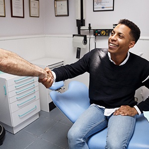 dentist and patient shaking over the cost of dental emergencies in Bettendorf