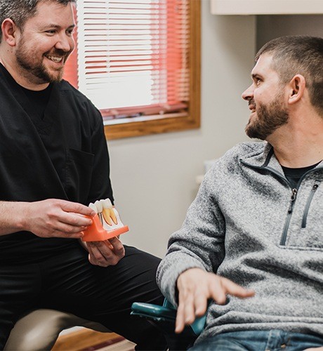 Dr. Pogue showing a patient how dental implants in Bettendorf work