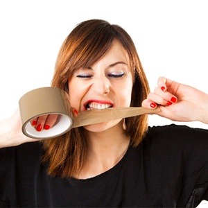 woman tearing off a piece of duct tape with her teeth