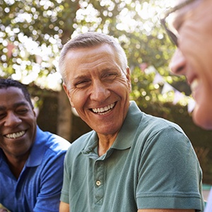 group of middle-aged men smiling outside