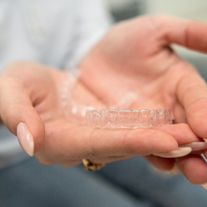 Closeup of woman holding clear aligner