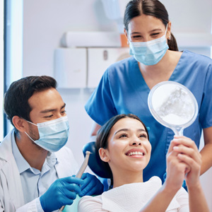 Patient looking at reflection in mirror with dentist