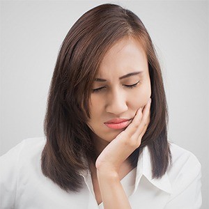 Woman in pain holding jaw