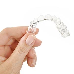 Hand holding a clear aligner tray