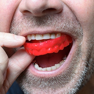 Closeup of man using red mouthguard