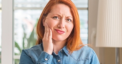 Woman in pain holding cheek