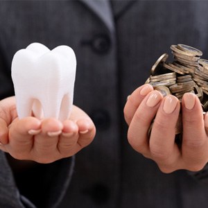 Molar and coins held in palm of hands