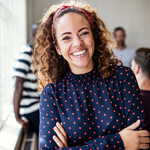 Woman with white teeth smiling next to team