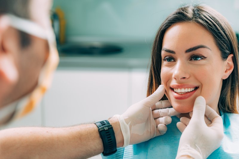 Cosmetic dentist examining patient's smile