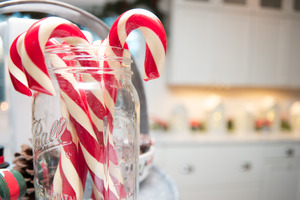 Candy canes in a glass jar on a kitchen cabinet