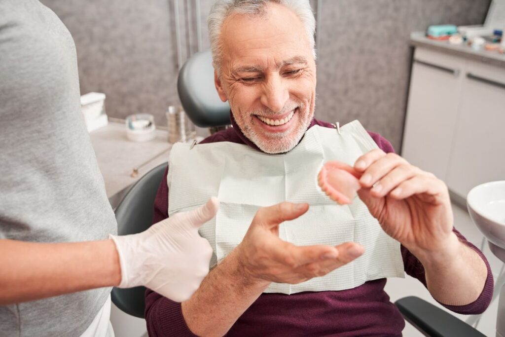 A man choosing dentures at his dentist’s office